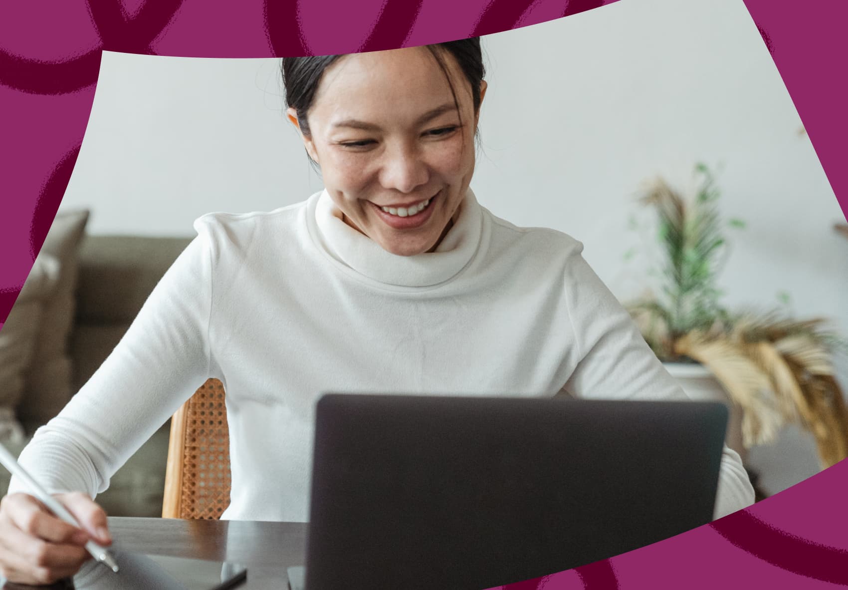 Smiling woman sitting in front of a laptop