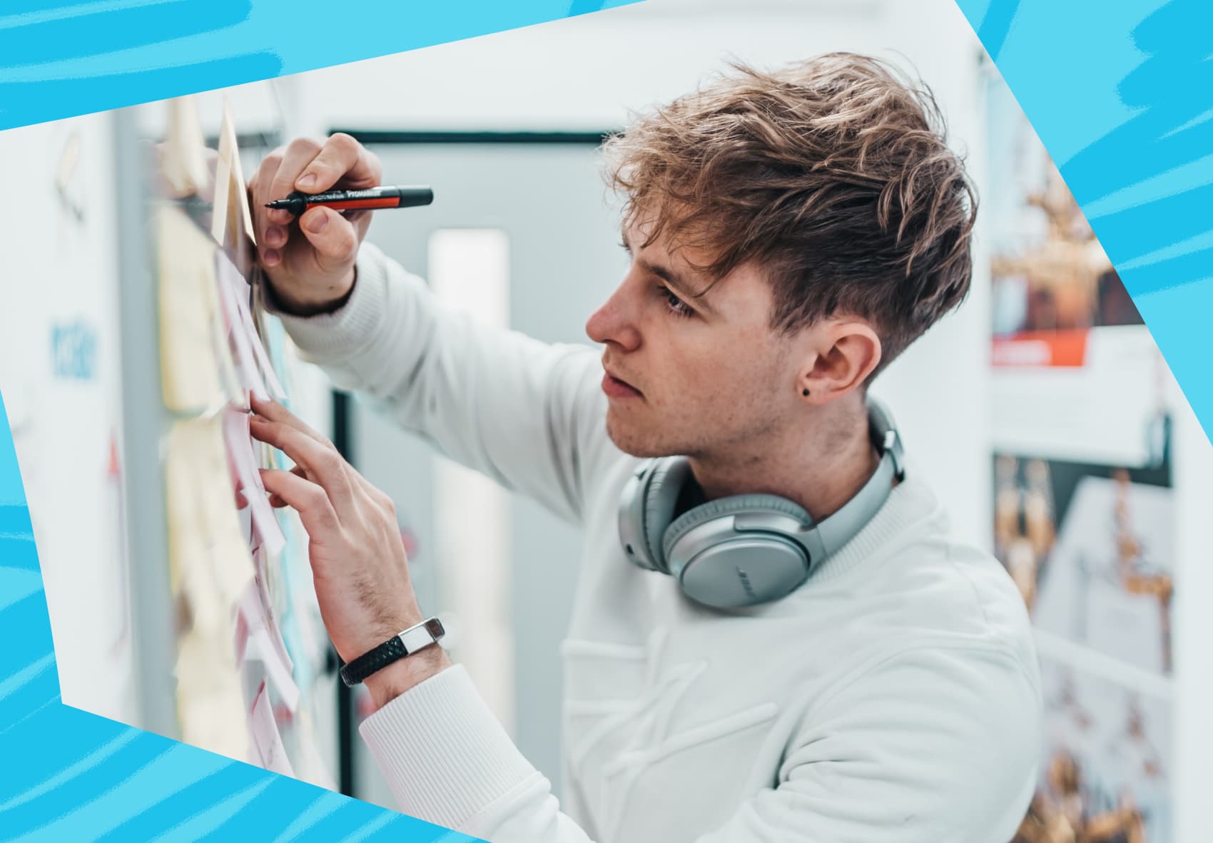 Man writing on post-it notes that are on a board
