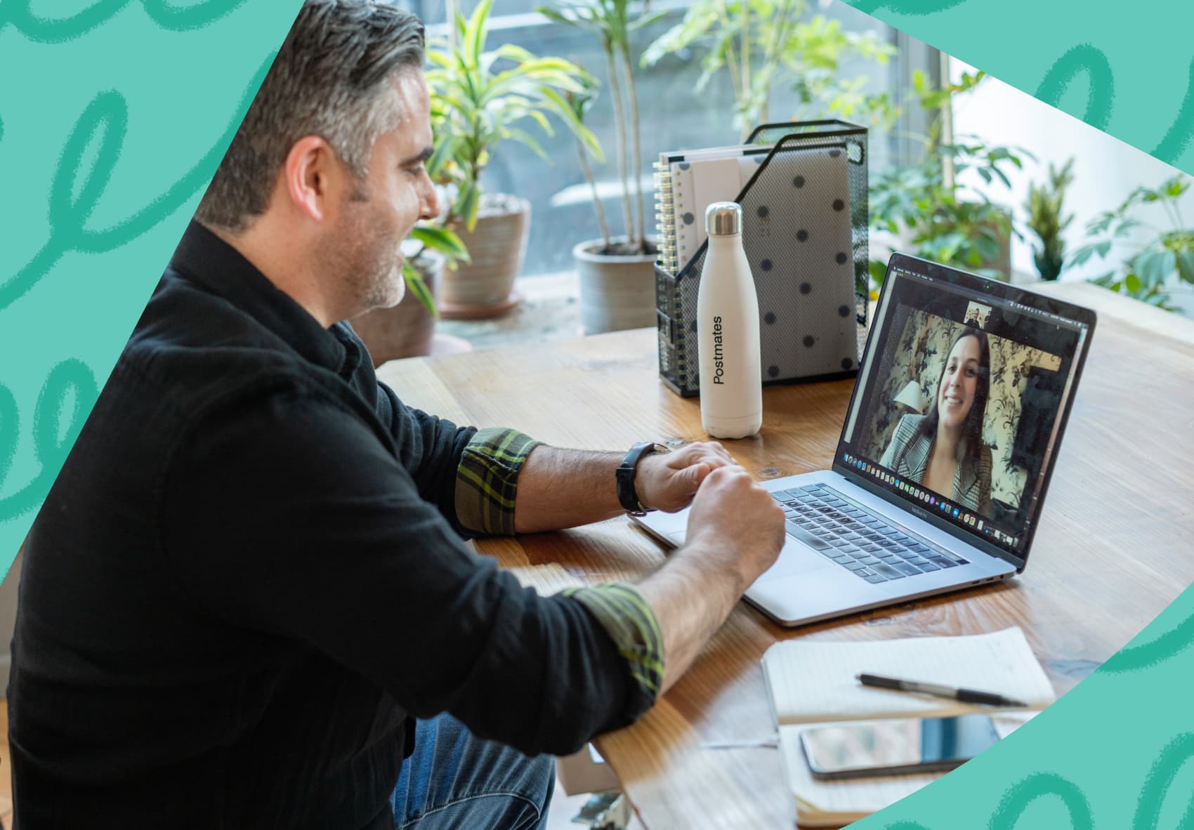 Man sitting at desk looking at laptop on a Zoom meeting